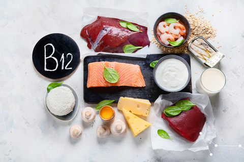 Vitamin B12 rich foods laid out on a grey/white background