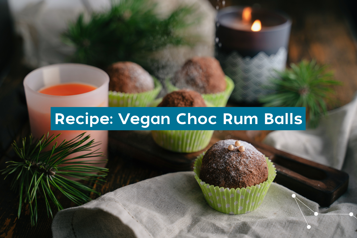 A Christmas setting on a table with linen hand towels, pine trees, candles and  rum balls in small green silicone cupcake holders